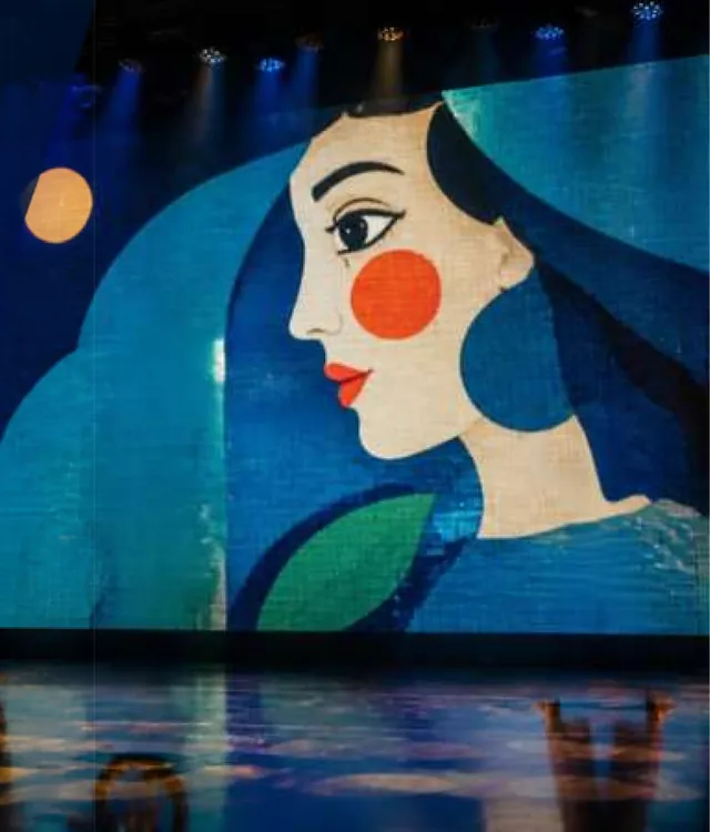 Painel de LED gigante com o rosto ilustrado de uma mulher sobre o palco