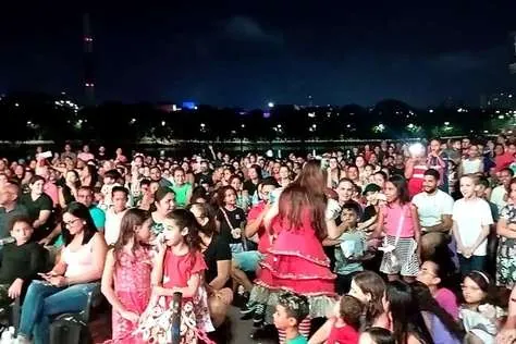 Público lotando uma praça à noite